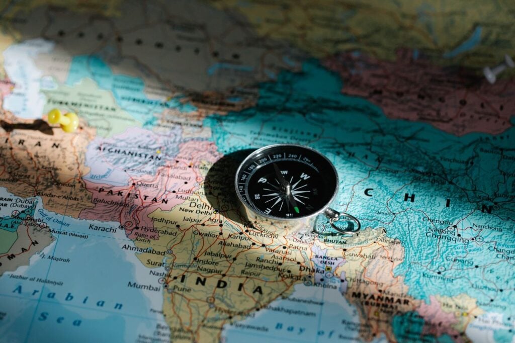 Compass resting on a world map Compass resting on a world map