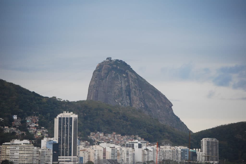 Sugarloaf Mountain rises above apartment buildings and hillside neighborhoods in Rio de Janeiro, Brazil.