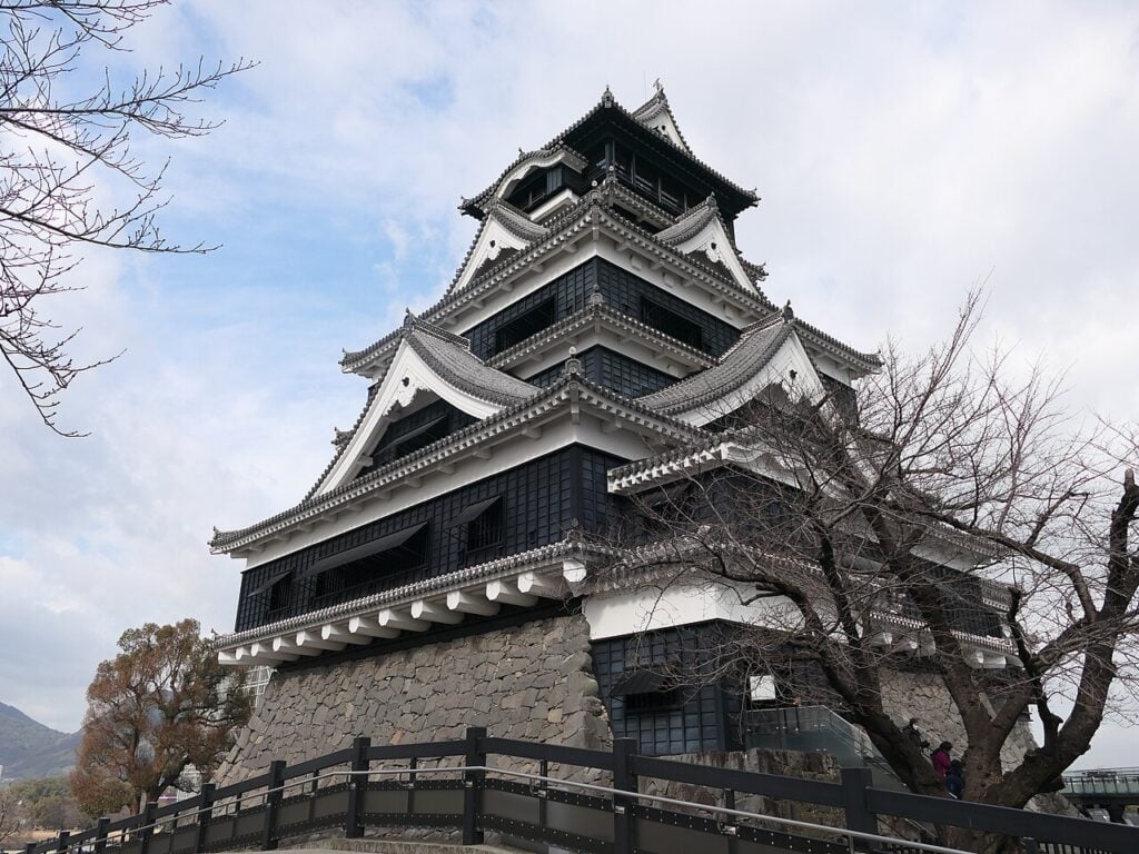 Kumamoto castle Black-and-white main keep of Kumamoto Castle rising above stone walls in Kumamoto, Japan