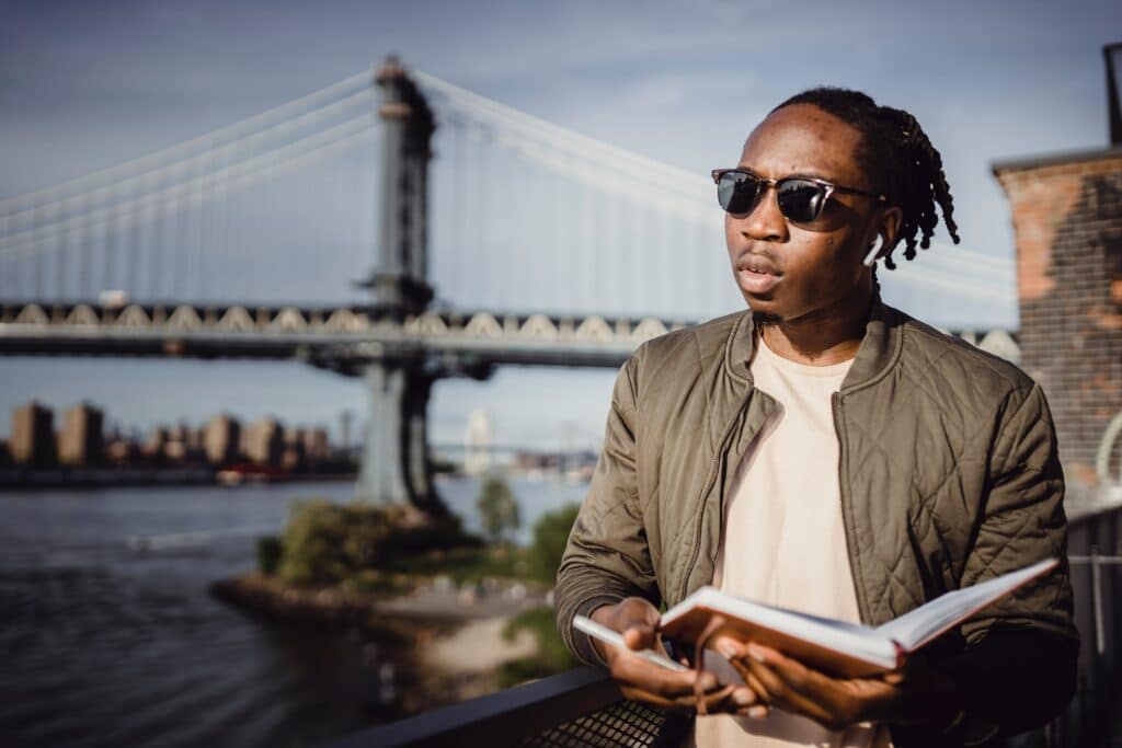 Black man traveling in front of a bridge
