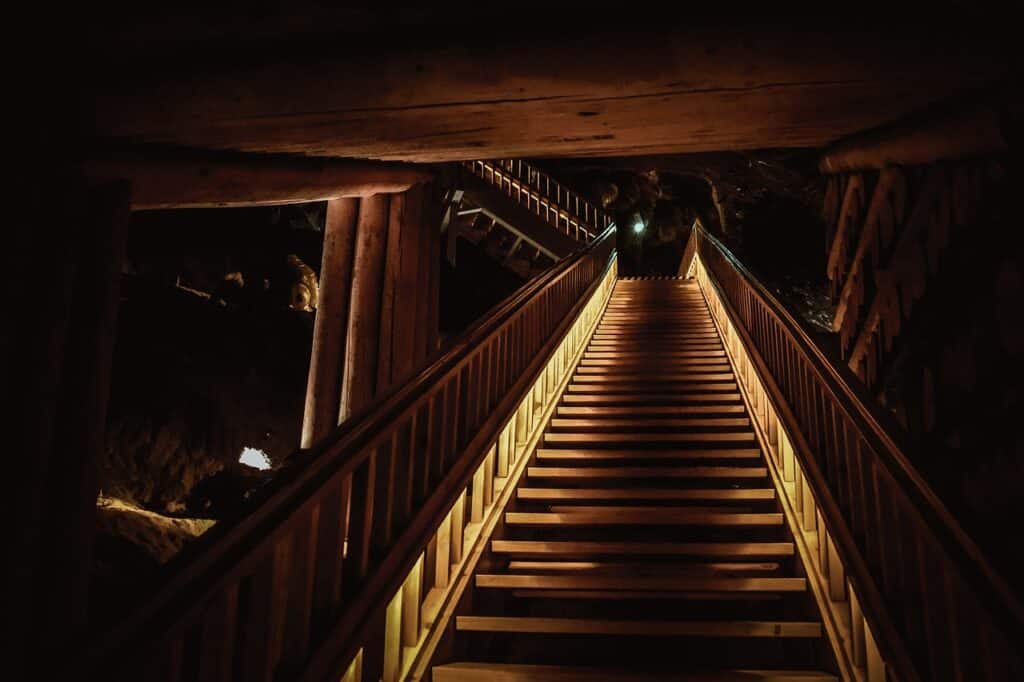 Stairs leading to one of the many Wieliczka Salt Mine routes Wooden staircase descending along the Wieliczka Salt Mine Tourist Route