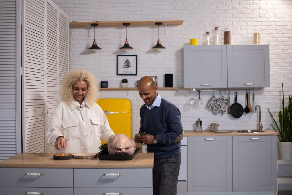 Photo by Tyson Black couple preparing a Thanksgiving turkey together in their home kitchen
