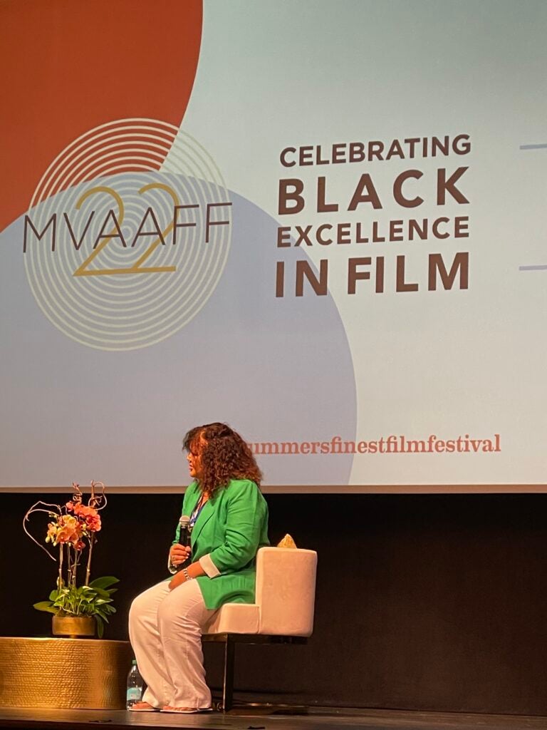 Filmmaker in green shirt sitting on stage and being interviewed at MVAAFF. photo by Tonya Fitzpatrick