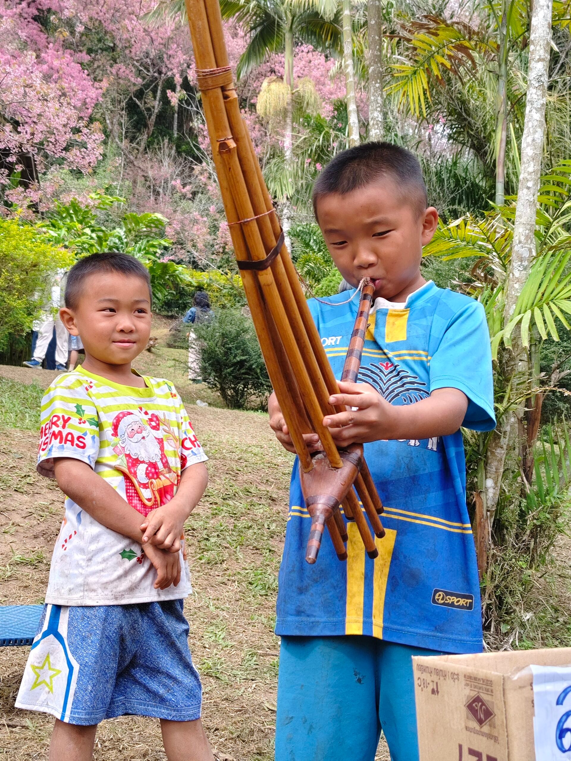 Village children play a bamboo mouth organ for tips. Photo Teh Chin Liang