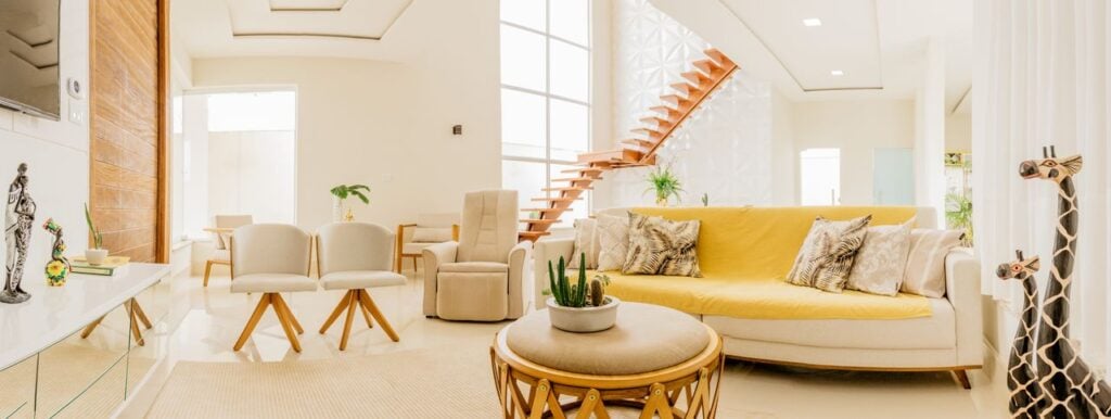 home exchange travel cultural immersion Bright residential living room with light-colored furniture and natural wood details