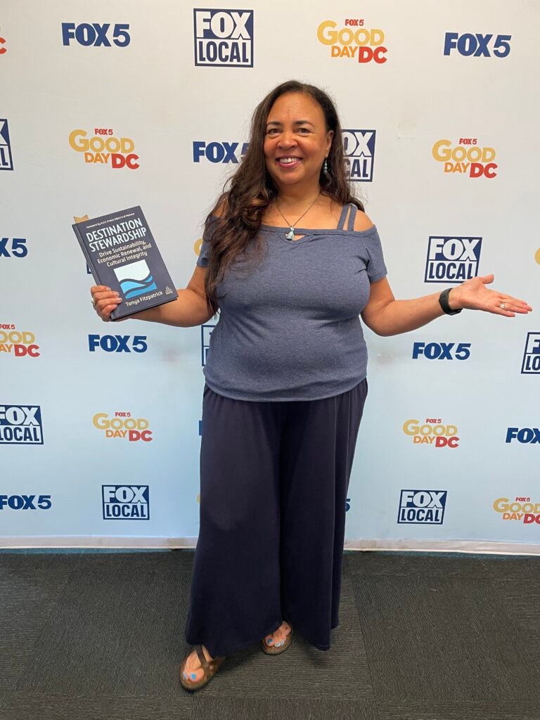Tonya Fitzpatrick posing with her acclaimed book, dDestination Stewardship, in the Fox 5 green room