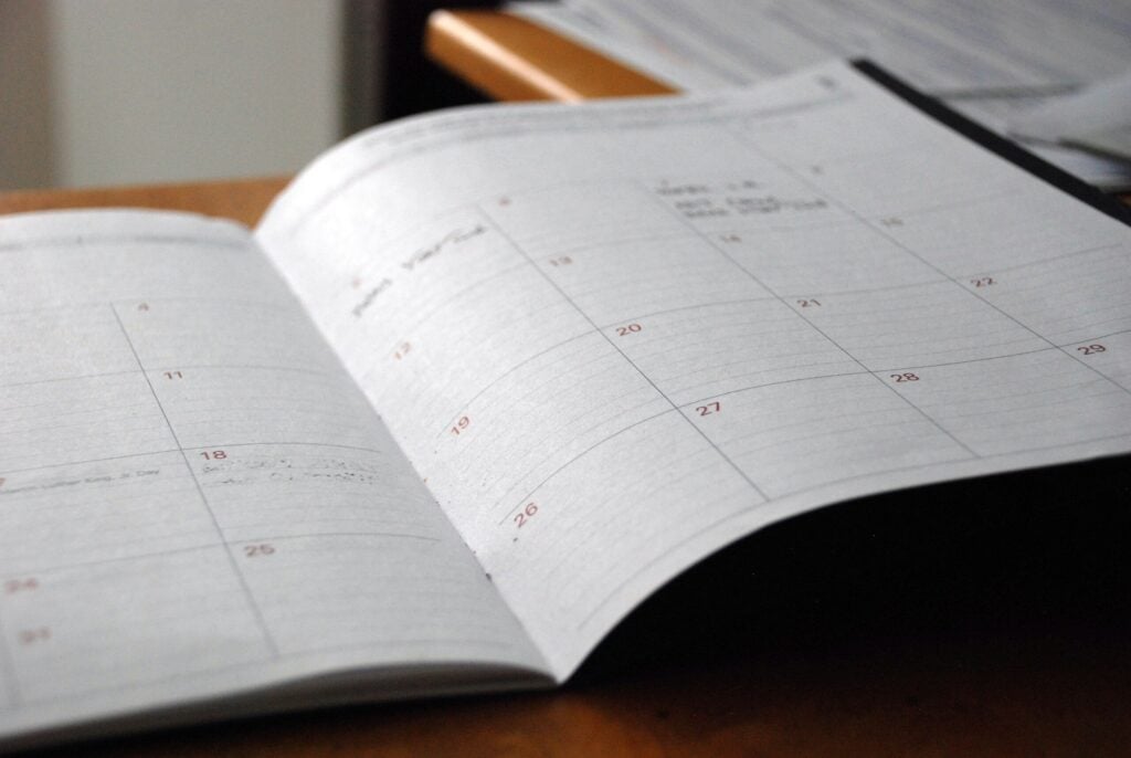 Photo by Eric Rothermel open monthly planner on wooden desk