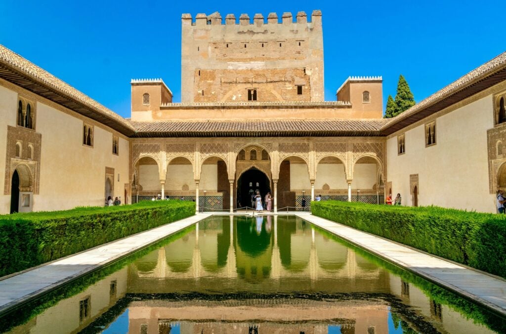 Court of the Myrtles reflecting pool and Comares Tower at the Alhambra in Granada, Spain