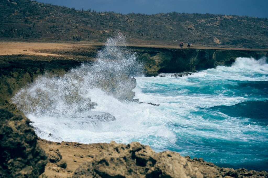 ocean waves crashing on shore in Aruba during daytime